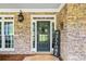 Stone front porch with a dark-green door and welcome sign at 4805 Blossom Ct, Cumming, GA 30028