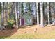 Green shed with a red door nestled among trees at 1237 Torrey Pl, Dacula, GA 30019