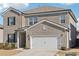 Two-story brick home with a white two-car garage and landscaped lawn at 4169 Wood Fern Ln, Buford, GA 30519