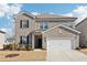 Two-story brick home with a white two-car garage and landscaped lawn at 4169 Wood Fern Ln, Buford, GA 30519