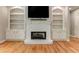 Living room fireplace with built-in shelving and hardwood floors at 5032 Hickory Hills Dr, Woodstock, GA 30188