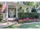 Landscaped front yard with flowers and a large porch at 5032 Hickory Hills Dr, Woodstock, GA 30188