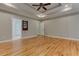 Main bedroom with hardwood floors, tray ceiling, and access to other rooms at 5032 Hickory Hills Dr, Woodstock, GA 30188