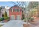 Brick front two-story home with two-car garage and landscaping at 588 Myrtle Trace Ln, Suwanee, GA 30024