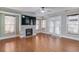 Cozy living room features a fireplace with tile surround, hardwood floors, and large windows at 588 Myrtle Trace Ln, Suwanee, GA 30024