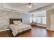 Spacious main bedroom featuring a tray ceiling, and decorative stone accent wall at 588 Myrtle Trace Ln, Suwanee, GA 30024