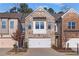 Brick front townhouse with a two-car garage and landscaping at 3360 Shelley Dr, Cumming, GA 30041