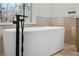 Modern bathroom featuring a freestanding tub with a black faucet and large window at 1362 Meadow Creek Nw Way, Acworth, GA 30102