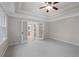 Spacious bedroom with tray ceiling, carpet, and door to bathroom at 1362 Meadow Creek Nw Way, Acworth, GA 30102