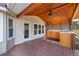 Covered porch showcasing an outdoor kitchen with wood ceiling, fan, and ample light at 1362 Meadow Creek Nw Way, Acworth, GA 30102