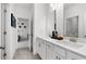 Bright bathroom with double vanity, white cabinets, and a view into an adjacent bedroom at 1603 Caldwell Bend Ln, Dacula, GA 30019