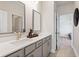Elegant bathroom featuring double sinks, modern fixtures, and a view of the bedroom at 1603 Caldwell Bend Ln, Dacula, GA 30019