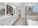 Bright, modern bathroom featuring double sinks, a glass shower, and a soaking tub at 1603 Caldwell Bend Ln, Dacula, GA 30019