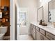 Well-lit bathroom featuring double sinks, neutral tones, and a peek into the bedroom at 1603 Caldwell Bend Ln, Dacula, GA 30019