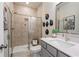 Elegant bathroom featuring a glass-enclosed shower, modern sink, vanity, and stylish wall decor at 1603 Caldwell Bend Ln, Dacula, GA 30019