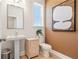 Powder room with pedestal sink, toilet, and accent wall at 1603 Caldwell Bend Ln, Dacula, GA 30019