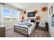 Charming bedroom with decorative flower wall art, comfortable bed, and lots of natural light from large windows at 1603 Caldwell Bend Ln, Dacula, GA 30019