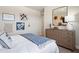 Comfortable bedroom with a light-colored dresser, bed and multiple floral themed decorations at 1603 Caldwell Bend Ln, Dacula, GA 30019