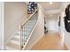 Hallway with stairs, light hardwood floors, neutral walls, and modern decor, creating a welcoming and stylish transition at 1603 Caldwell Bend Ln, Dacula, GA 30019