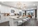 Elegant white kitchen with a large island, modern appliances, and stylish pendant lighting and bar stools at 1603 Caldwell Bend Ln, Dacula, GA 30019