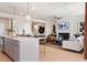 Kitchen with island, pendant lights, and seating open to the living room with a fireplace at 1603 Caldwell Bend Ln, Dacula, GA 30019