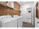 Functional laundry room with modern appliances, ample shelving, and wood look floors at 1603 Caldwell Bend Ln, Dacula, GA 30019