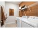 Well-lit laundry room featuring modern washer and dryer, overhead shelving, and stylish wall decor at 1603 Caldwell Bend Ln, Dacula, GA 30019