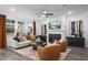 Bright living room with fireplace, modern furnishings, and large windows showcasing backyard views at 1603 Caldwell Bend Ln, Dacula, GA 30019
