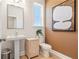 Stylish powder room features a pedestal sink, accent art, and cabinet storage at 1603 Caldwell Bend Ln, Dacula, GA 30019