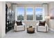 Bright sitting area with floor-to-ceiling windows and comfortable arm chairs at 1603 Caldwell Bend Ln, Dacula, GA 30019