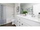 Well-lit bathroom with double sink vanity, white cabinetry, and a shower-tub combination at 512 Altamaha Ct, Locust Grove, GA 30248