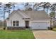 White farmhouse style home with gray stone accents and a two-car garage at 512 Altamaha Ct, Locust Grove, GA 30248