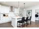 Modern kitchen with a center island, stainless steel appliances, and an adjacent laundry room at 512 Altamaha Ct, Locust Grove, GA 30248