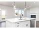 White kitchen island with black faucet and view into Gathering room at 512 Altamaha Ct, Locust Grove, GA 30248