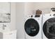 Modern laundry room featuring a front load washer and dryer next to a utility sink at 512 Altamaha Ct, Locust Grove, GA 30248