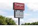 Tanger Outlets sign with various store logos against a partly cloudy sky at 512 Altamaha Ct, Locust Grove, GA 30248