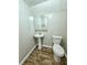 Small bathroom with pedestal sink, toilet and updated floor at 4550 Cypress Ridge Ct, Stone Mountain, GA 30083