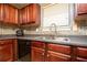 Modern kitchen with dark wood cabinets, black appliances, and tile backsplash at 2513 Sonoma Vly, Villa Rica, GA 30180