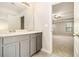 Double vanity bathroom with gray cabinets and a view of a bedroom at 2784 Cypress Rdg, Loganville, GA 30052