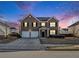 Traditional two-story brick home featuring a two-car garage, well-manicured lawn, under beautiful skies at 2784 Cypress Rdg, Loganville, GA 30052