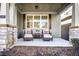 Relaxing front porch with wicker chairs, side table, and view of landscaping at 340 Glens Way, Woodstock, GA 30188