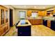 Traditional kitchen with light wood cabinets, black appliances, and stained glass window above sink at 850 Airline Rd, Mcdonough, GA 30252