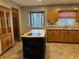 Kitchen with island, wood cabinets, and stained glass window at 850 Airline Rd. Rd, Mcdonough, GA 30252