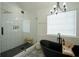 Spa-like bathroom featuring a soaking tub, walk-in shower, and black and white tile at 12558 Lakeside Pkwy, Fayetteville, GA 30215