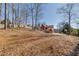 Sloped backyard with basketball court and wooded area at 180 Paces Lakes Pointe St, Dallas, GA 30157