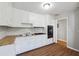 Eat-in kitchen featuring white cabinets, gas range, and wood-look flooring at 8554 Taylor Rd, Riverdale, GA 30274