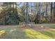 Serene backyard with wooden benches and a lamp post, surrounded by lush trees at 200 Mcguirts Bridge Rd, Covington, GA 30014