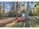 Secluded backyard area with red Adirondack chairs and a storage building offers a peaceful retreat at 200 Mcguirts Bridge Rd, Covington, GA 30014