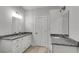 Bathroom with granite countertops, double sinks, and a large mirror at 410 N Carroll N St, Bowdon, GA 30108