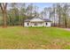 Modern farmhouse exterior with white siding, gray roof, and wood accents at 410 N Carroll N St, Bowdon, GA 30108